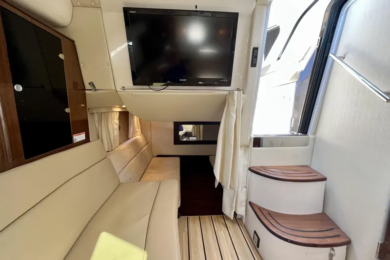  Yacht Photos Pics Interior of 2013 Regal 35 Sport Coupe with TV, beige seating, and wooden steps.