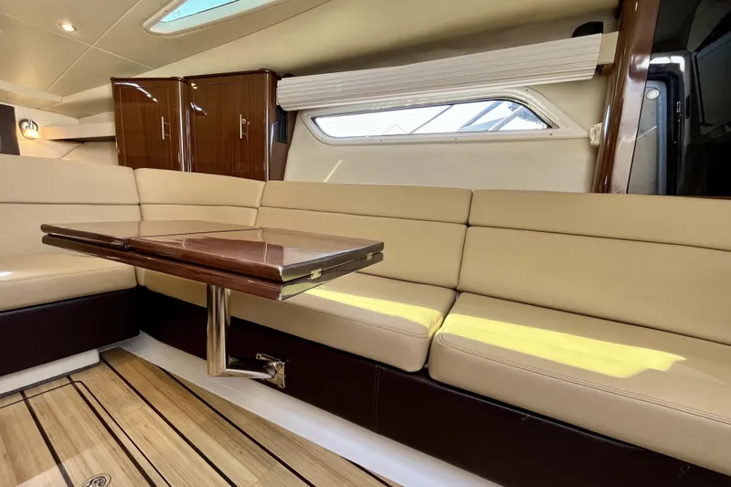  Yacht Photos Pics Luxurious interior of 2013 Regal 35 Sport Coupe with beige seating and wooden table.