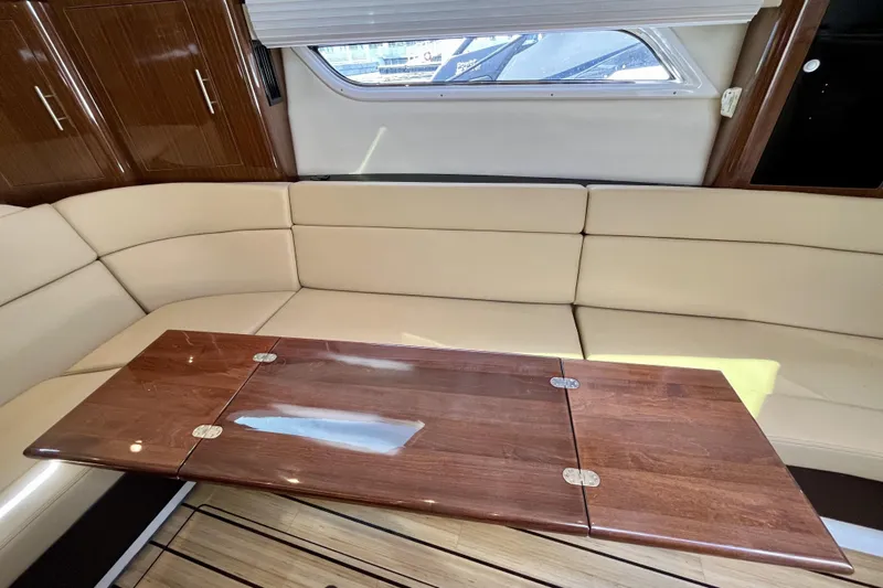  Yacht Photos Pics Luxurious interior of 2013 Regal 35 Sport Coupe with beige seating and wooden table.