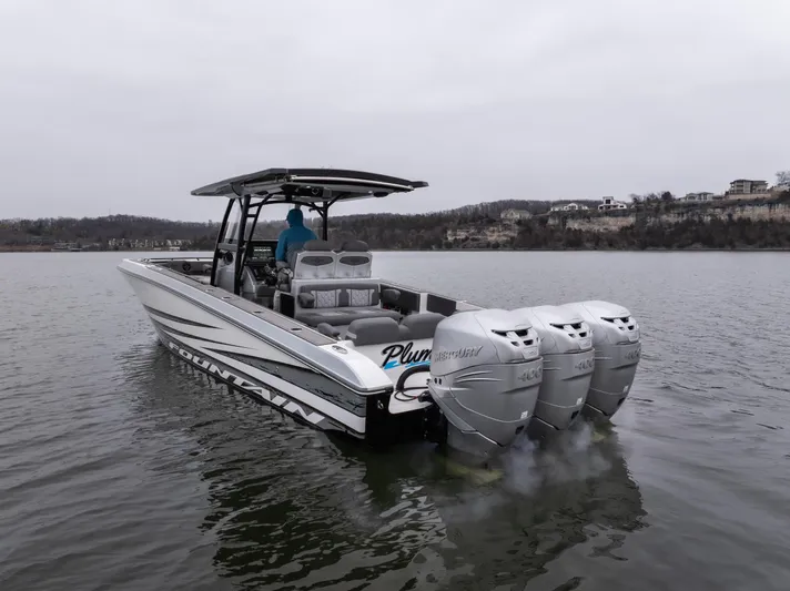  Yacht Photos Pics 2022 Fountain 38 SC boat with triple outboard engines on a calm lake.