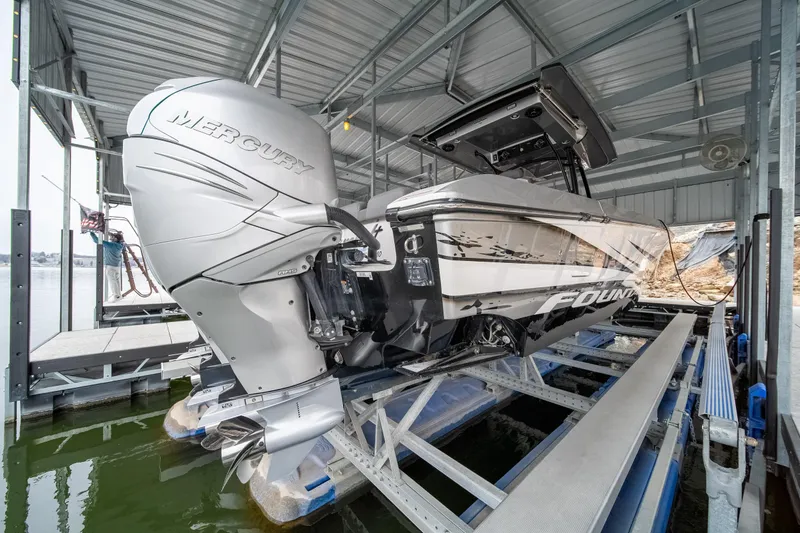  Yacht Photos Pics 2022 Fountain 38 SC boat with Mercury outboard engine in a covered dock.