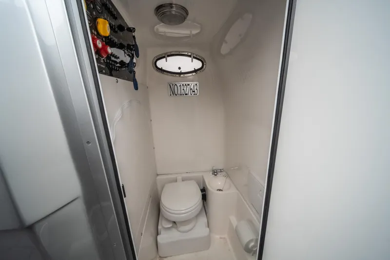  Yacht Photos Pics 2022 Fountain 38 SC boat interior bathroom with toilet and porthole window.