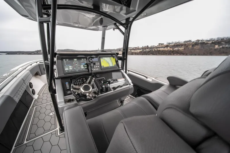  Yacht Photos Pics 2022 Fountain 38 SC boat cockpit with advanced navigation system on a calm lake.