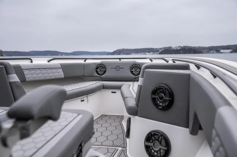  Yacht Photos Pics 2022 Fountain 38 SC boat interior with gray seating and speakers, on a calm lake.