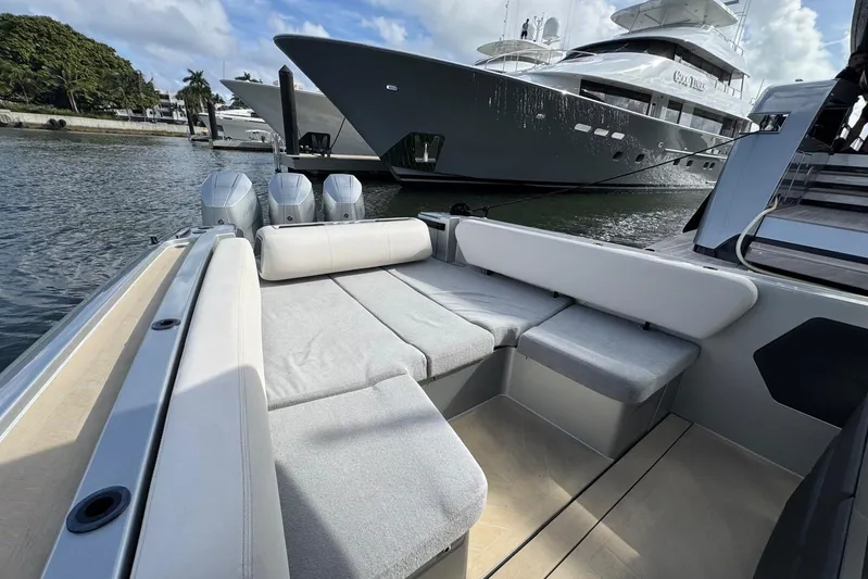 T/t Tenacious Yacht Photos Pics 2025 Wajer 38s luxury boat interior with plush seating, docked near a large yacht.