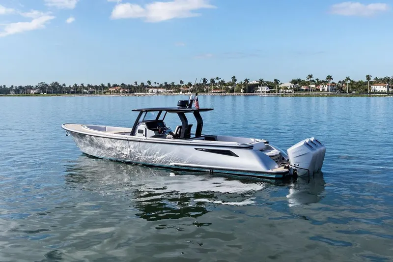 T/t Tenacious Yacht Photos Pics 2025 Wajer 38s luxury boat on calm water with scenic shoreline background.