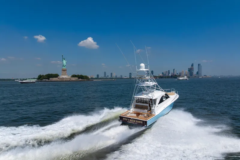  Yacht Photos Pics Cabo 44 Hardtop Express 2012 cruising near Statue of Liberty, New York City skyline in background.