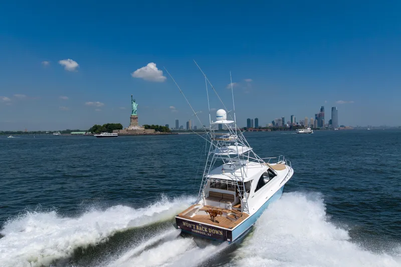  Yacht Photos Pics 2012 Cabo 44 Hardtop Express yacht near Statue of Liberty, New York City skyline in background.