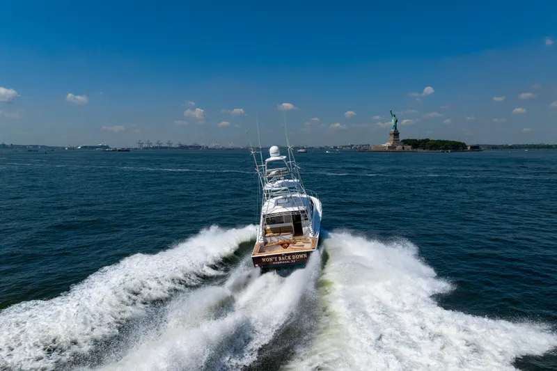  Yacht Photos Pics Cabo 44 Hardtop Express 2012 cruising near Statue of Liberty on a sunny day.