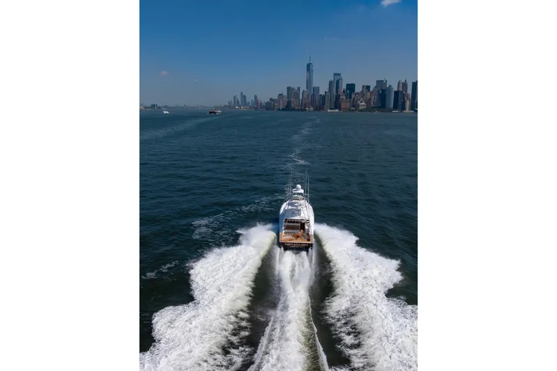  Yacht Photos Pics Cabo 44 Hardtop Express 2012 cruising near city skyline on a sunny day.