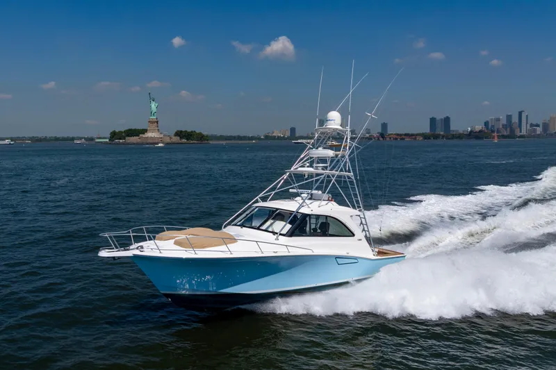  Yacht Photos Pics 2012 Cabo 44 Hardtop Express cruising near the Statue of Liberty on a sunny day.