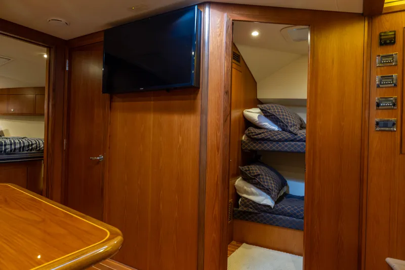  Yacht Photos Pics Interior of 2012 Cabo 44 Hardtop Express with cozy bunk beds and wooden finish.