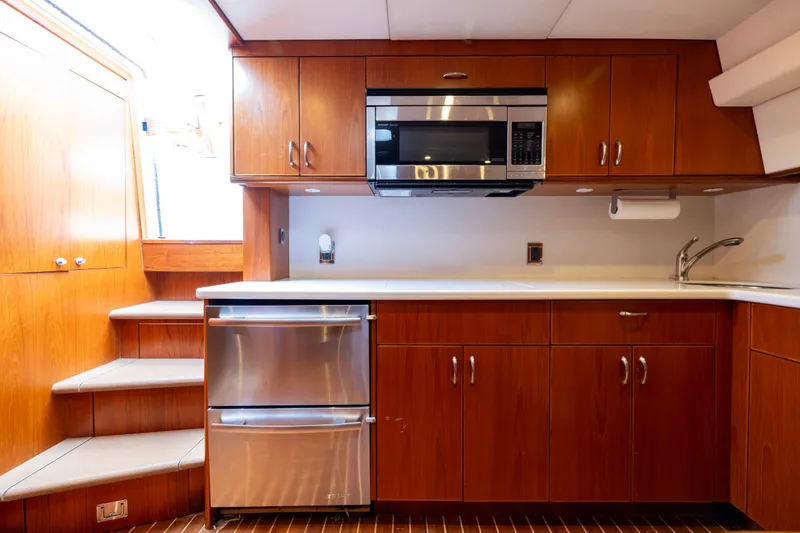 Yacht Photos Pics Luxurious 2012 Cabo 44 Hardtop Express yacht kitchen with wood cabinetry and modern appliances.