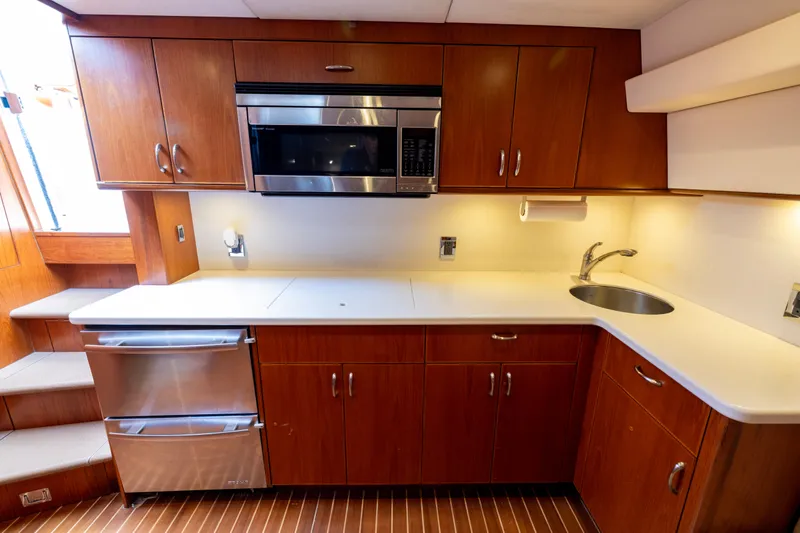  Yacht Photos Pics 2012 Cabo 44 Hardtop Express yacht kitchen with wood cabinets, microwave, and sink.