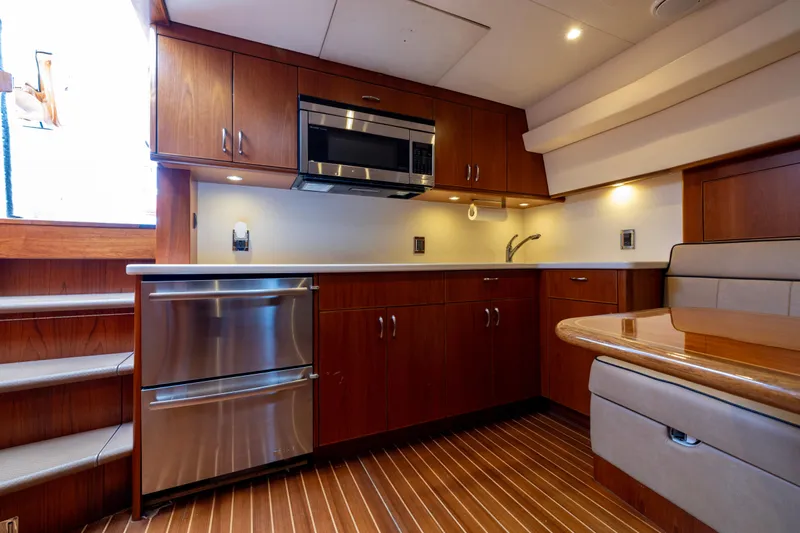  Yacht Photos Pics Luxurious 2012 Cabo 44 Hardtop Express yacht interior with modern kitchen and dining area.