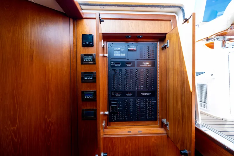  Yacht Photos Pics Electrical control panel inside 2012 Cabo 44 Hardtop Express yacht, featuring wooden cabinetry.