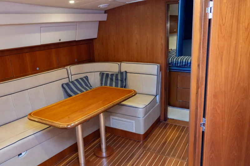  Yacht Photos Pics Interior of 2012 Cabo 44 Hardtop Express yacht with wooden dining area and seating.