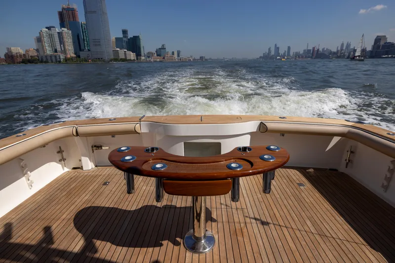  Yacht Photos Pics 2012 Cabo 44 Hardtop Express yacht cruising with city skyline in background.
