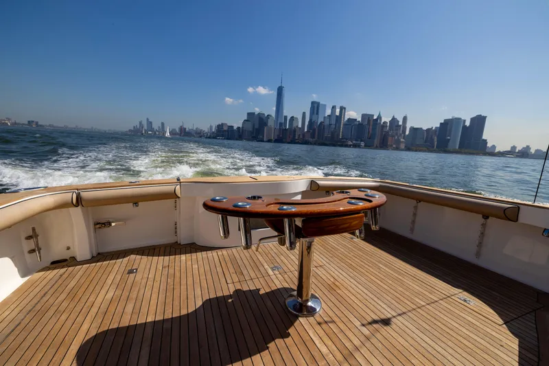  Yacht Photos Pics 2012 Cabo 44 Hardtop Express yacht cruising with city skyline view.