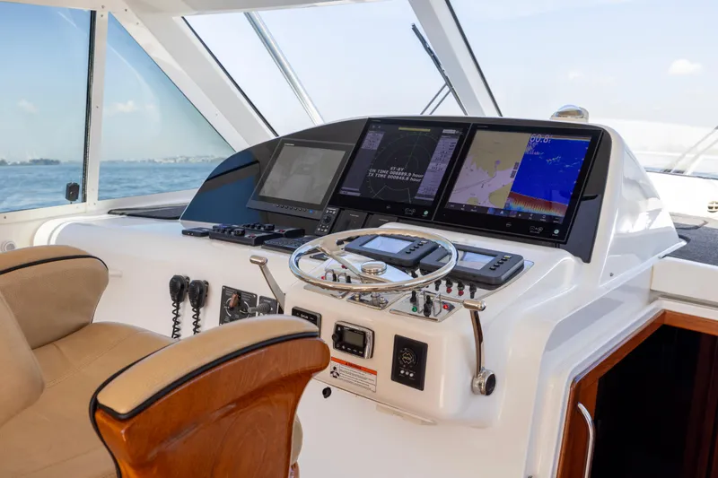  Yacht Photos Pics Helm of 2012 Cabo 44 Hardtop Express with navigation screens and steering wheel.