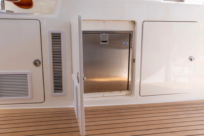  Yacht Photos Pics 2012 Cabo 44 Hardtop Express yacht interior with open storage compartment and wooden flooring.