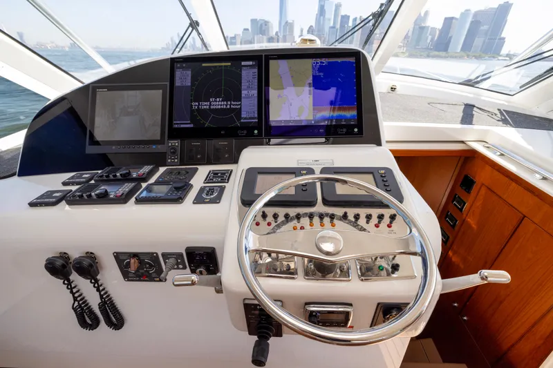  Yacht Photos Pics Control panel of 2012 Cabo 44 Hardtop Express yacht with city skyline view.