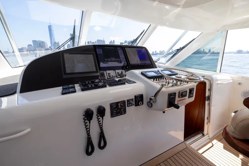  Yacht Photos Pics Helm of 2012 Cabo 44 Hardtop Express yacht with city skyline view.