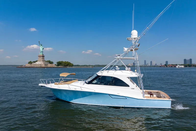  Yacht Photos Pics 2012 Cabo 44 Hardtop Express yacht near Statue of Liberty on sunny day.