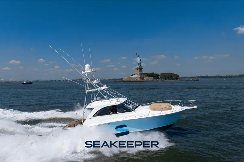  Yacht Photos Pics Cabo 44 Hardtop Express 2012 cruising near Statue of Liberty on a sunny day.