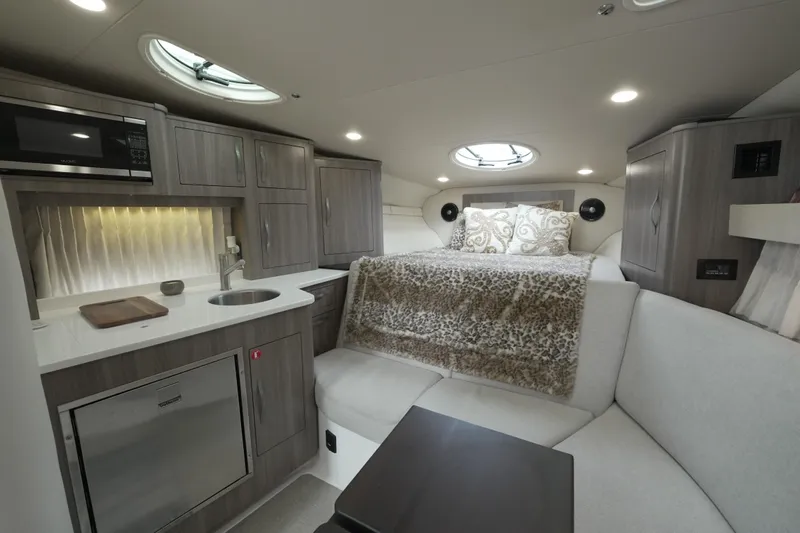  Yacht Photos Pics Luxurious interior of 2021 Regal 33 XO yacht with modern kitchen and cozy sleeping area.