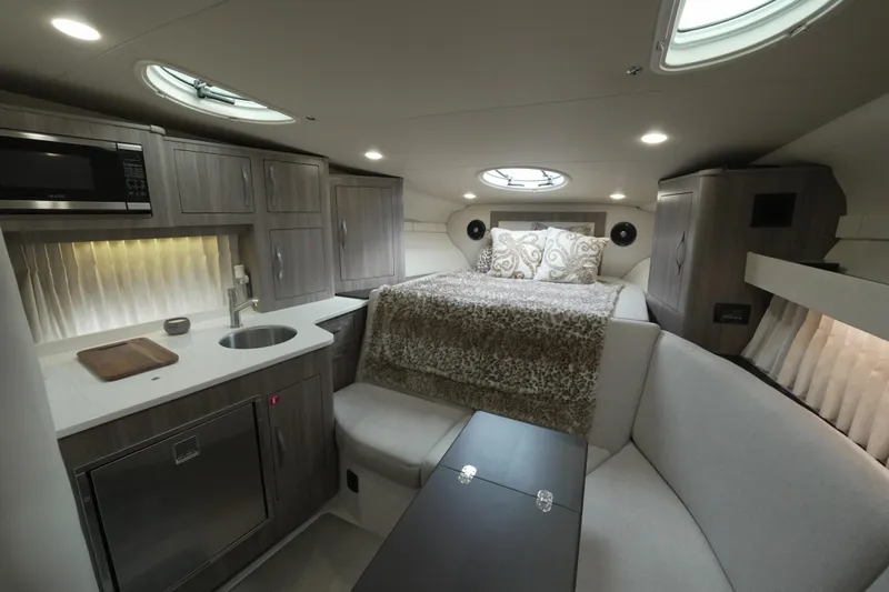  Yacht Photos Pics Luxurious interior of 2021 Regal 33 XO yacht with kitchenette and cozy sleeping area.