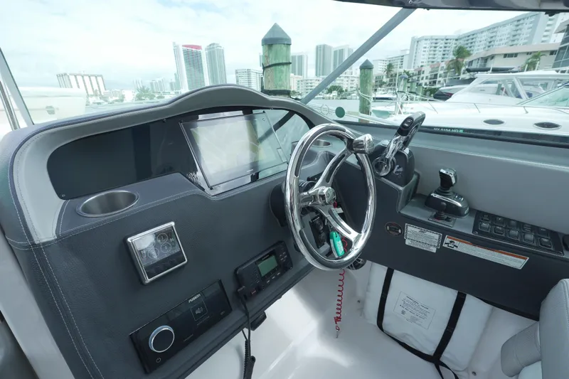  Yacht Photos Pics 2021 Regal 33 XO boat helm with modern controls and cityscape background.