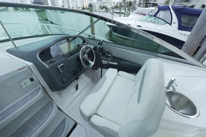  Yacht Photos Pics 2021 Regal 33 XO boat cockpit with steering wheel and sink, docked in marina.