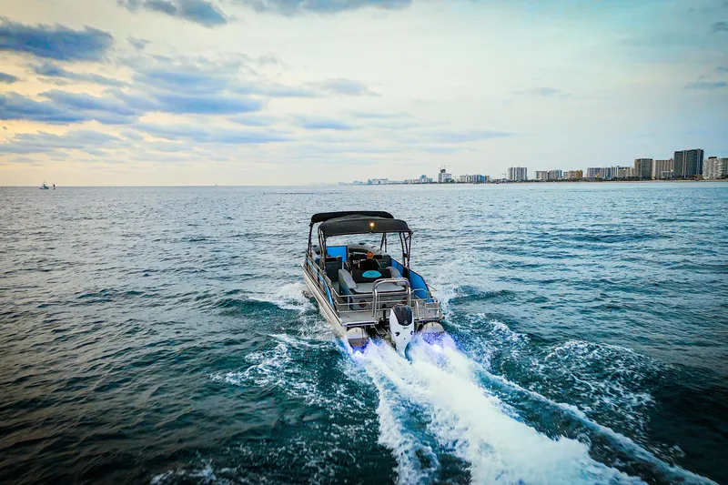  Yacht Photos Pics 2025 Vision Marine Technologies V30 boat cruising on open water near city skyline.