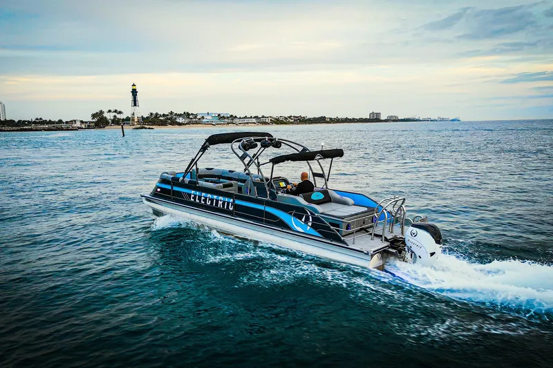 Yacht Photos Pics Electric Vision Marine Technologies V30 boat cruising near a lighthouse, 2025 model.