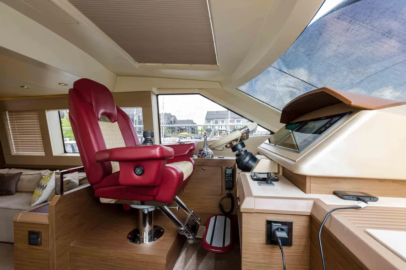  Yacht Photos Pics Luxurious helm of 2017 Beneteau Monte Carlo 6S yacht with red captain's chair.