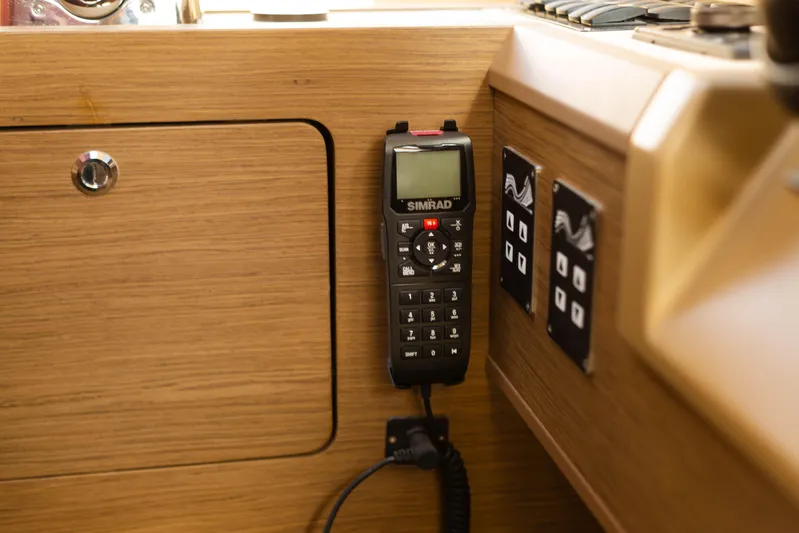  Yacht Photos Pics Simrad radio on 2017 Beneteau Monte Carlo 6S yacht interior, wooden paneling, control switches.