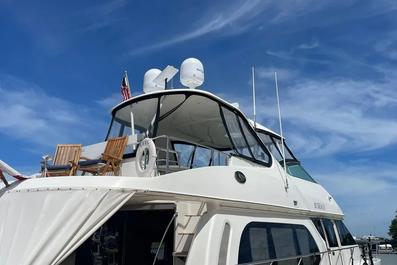 Susea Q Yacht Photos Pics 2005 Carver 560 Voyager yacht with upper deck chairs under a clear blue sky.