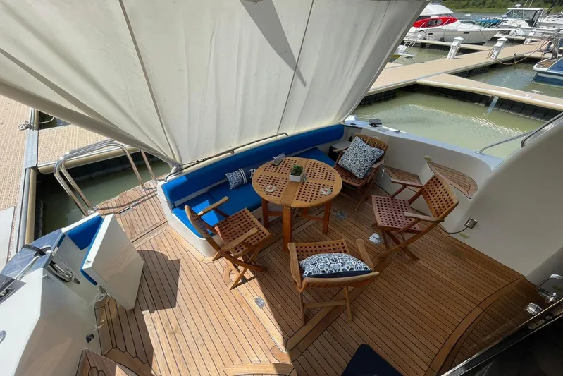 Susea Q Yacht Photos Pics 2005 Carver 560 Voyager yacht deck with wooden furniture and blue cushions at marina.