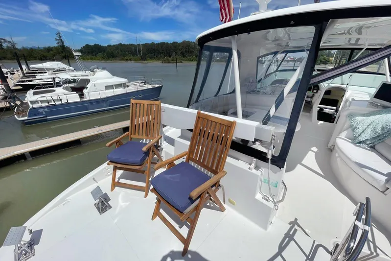 Susea Q Yacht Photos Pics 2005 Carver 560 Voyager yacht deck with wooden chairs, docked at marina.
