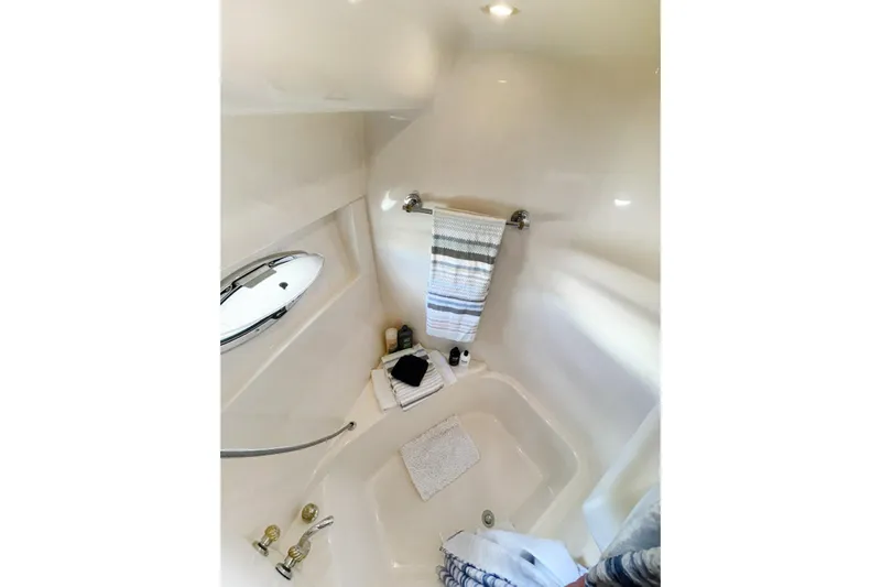 Susea Q Yacht Photos Pics Bathroom interior of 2005 Carver 560 Voyager yacht, featuring a bathtub and striped towel.