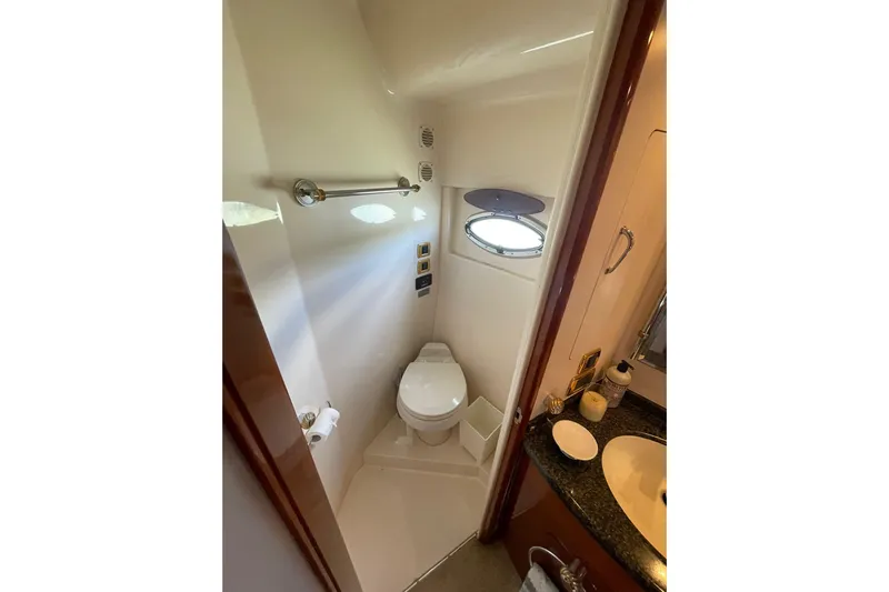 Susea Q Yacht Photos Pics Compact bathroom in 2005 Carver 560 Voyager yacht with toilet, sink, and porthole window.