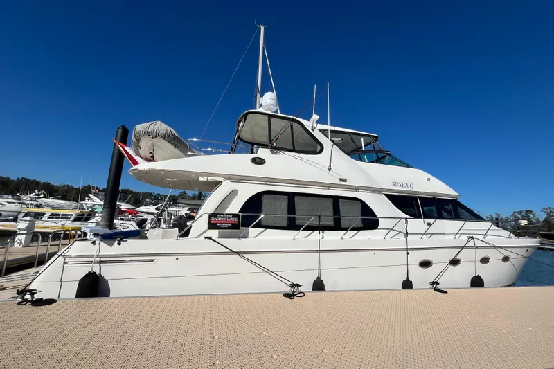 Susea Q Yacht Photos Pics 2005 Carver 560 Voyager yacht docked at marina under clear blue sky.