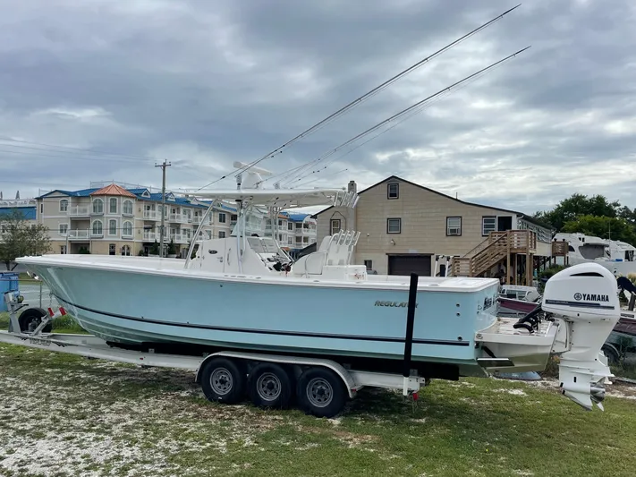  Yacht Photos Pics 2015 Regulator 34 boat on trailer with Yamaha engines, parked near residential area.