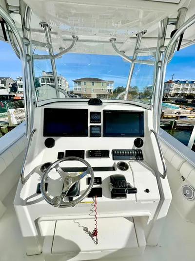  Yacht Photos Pics 2015 Regulator 34 boat cockpit with dual screens and steering wheel, docked in a marina.