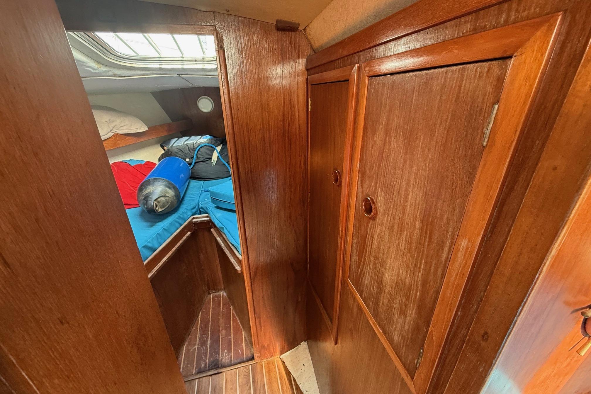 1984 Trapper T30 yacht interior with wooden cabinetry and cozy sleeping area.