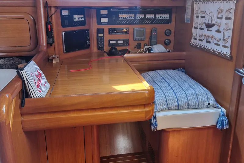  Yacht Photos Pics Interior of 2002 Grand Soleil 43 yacht with navigation equipment and cozy seating area.
