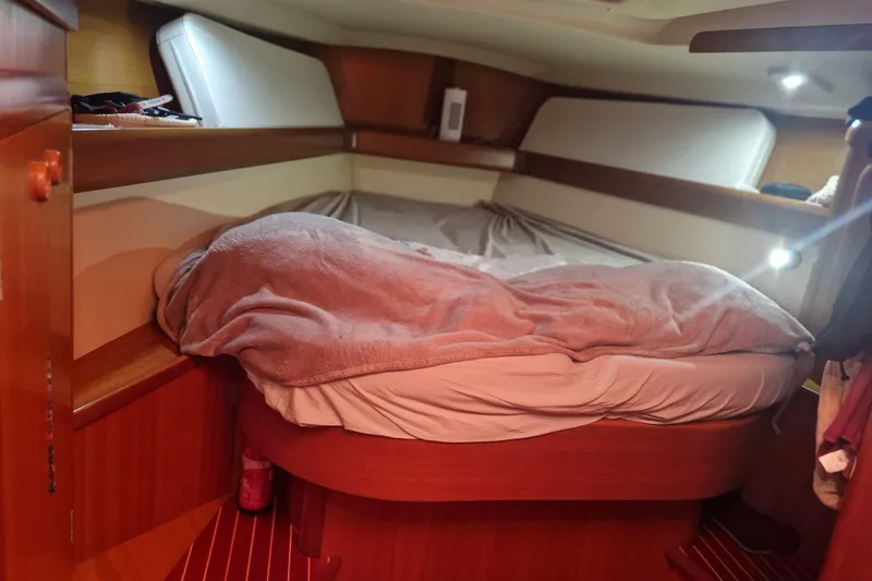  Yacht Photos Pics Cozy cabin interior of 2002 Grand Soleil 43 sailboat with wooden finish and bedding.