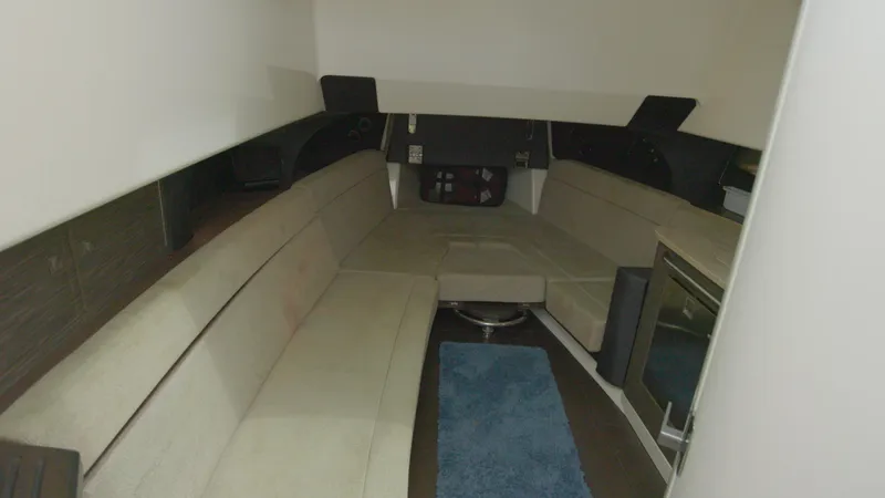  Yacht Photos Pics Interior cabin of a 2016 Boston Whaler 420 Outrage with beige seating and blue rug.