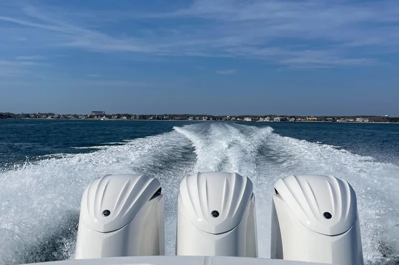  Yacht Photos Pics 2022 Regulator 34 boat with triple engines cruising on open water.